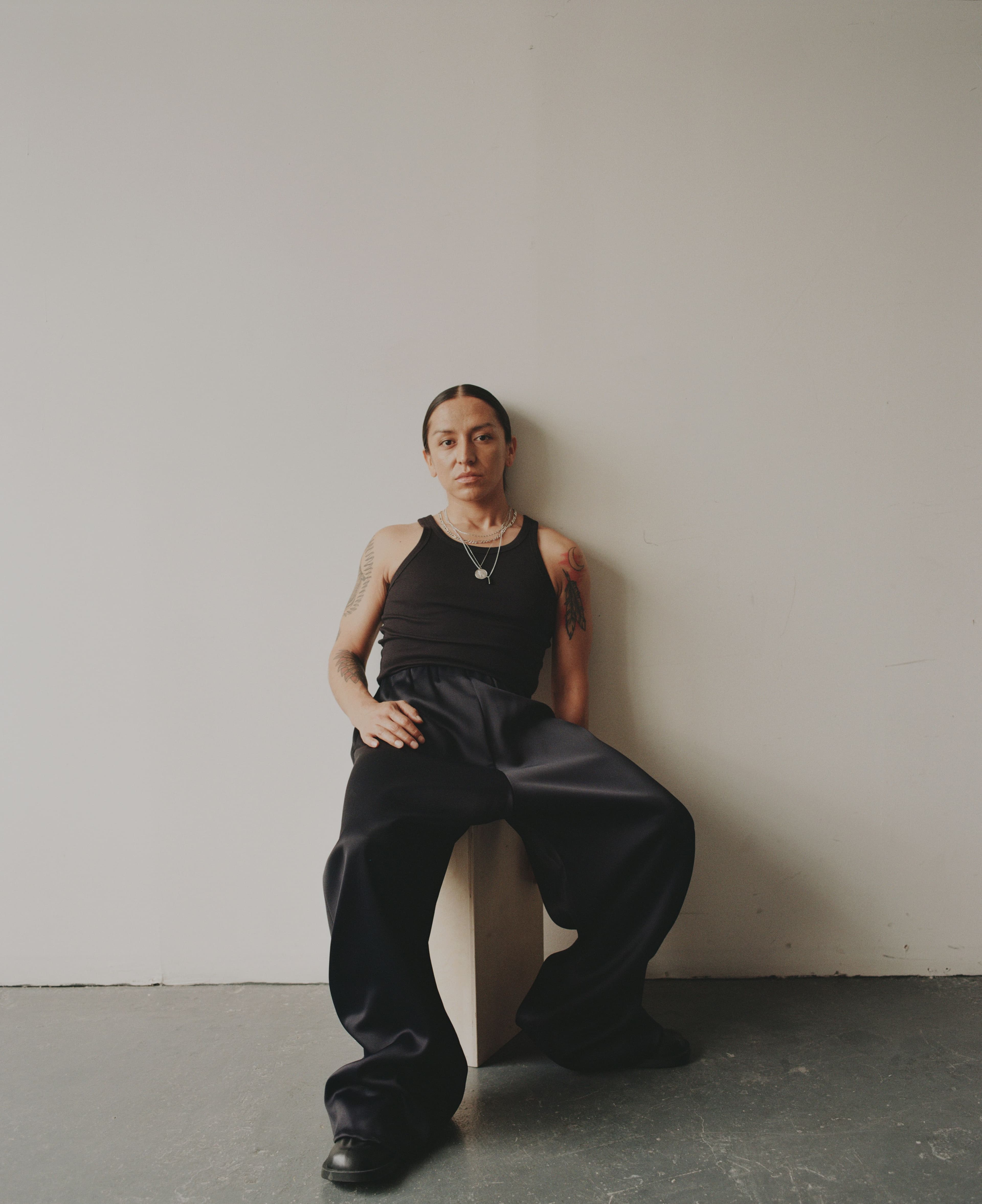 TOP by ,Calvin Klein. ,PANTS by ,FFORME. ,SHOES by ,Camper Lab. ,NECKLACES by ,Miansai ,and Lopez’s own.