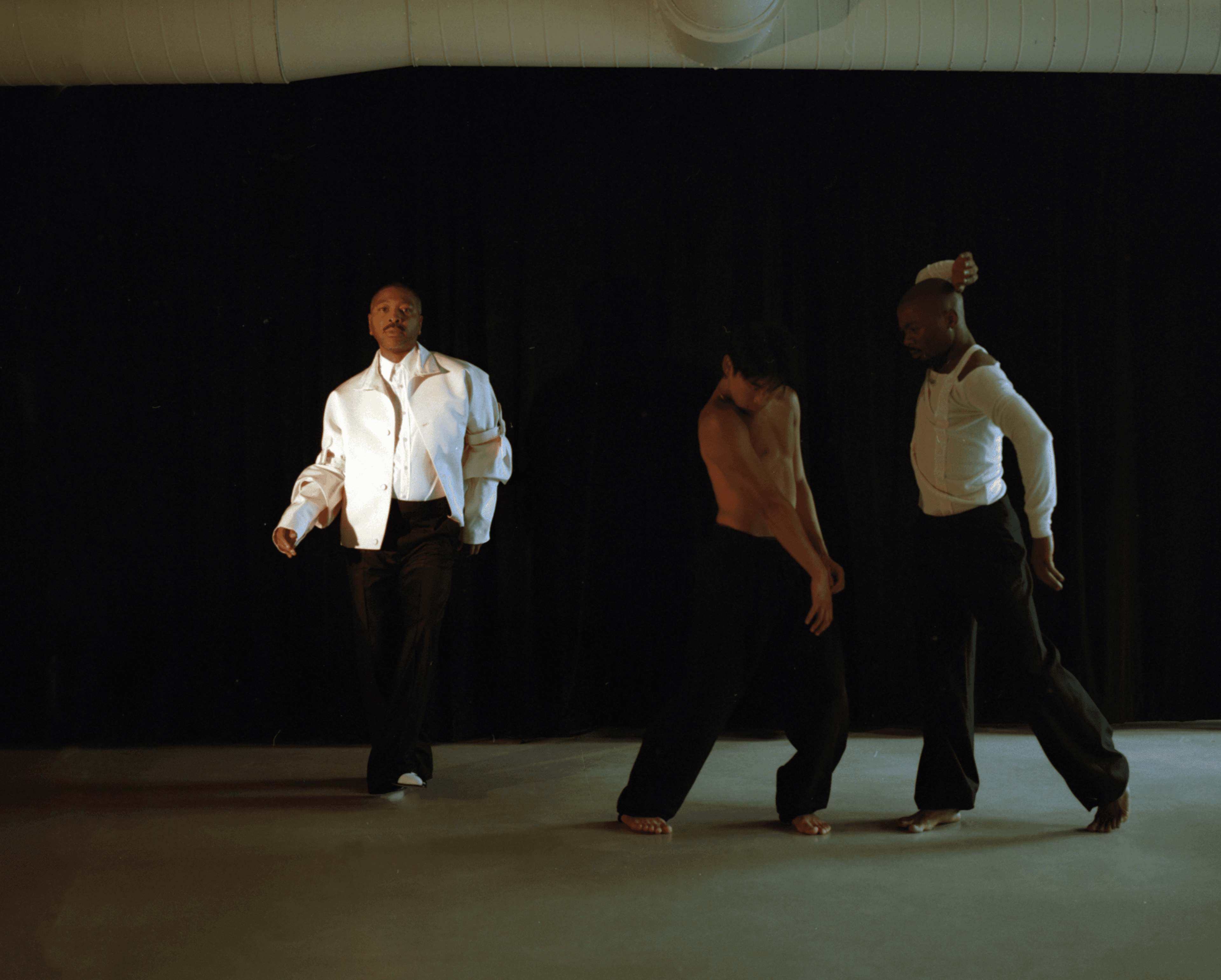 FROM LEFT: Abraham wears JACKET and PANTS by Dior; SHIRT by Dries Van Noten; SHOES by Manolo Blahnik. Okajima wears PANTS by Ferragamo. Bowman wears TOP by Dior,; ,PANTS by Dries Van Noten,.